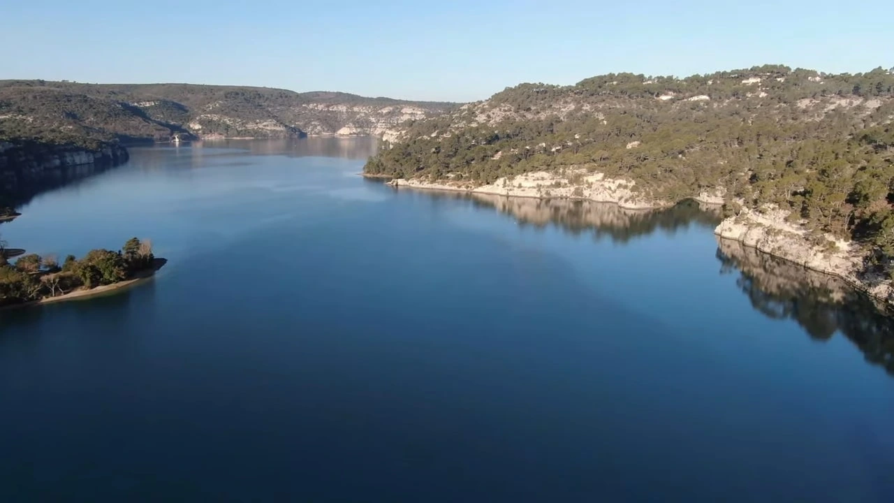 Les eaux calmes du Lac d'Esparron bordées de falaises calcaires