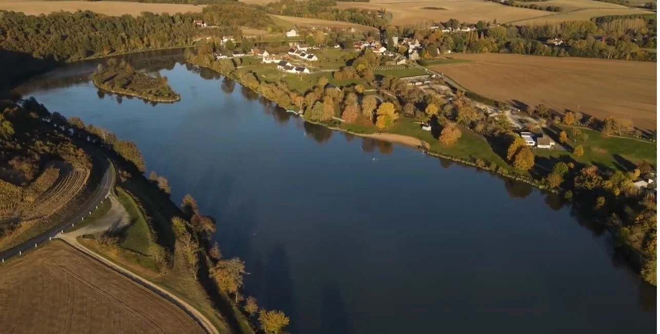 Vue sur le plan d'eau aménagé du Lac de Chemillé-sur-Indrois en Touraine, montrant un cadre verdoyant et calme idéal pour les loisirs en famille et le tourisme vert.