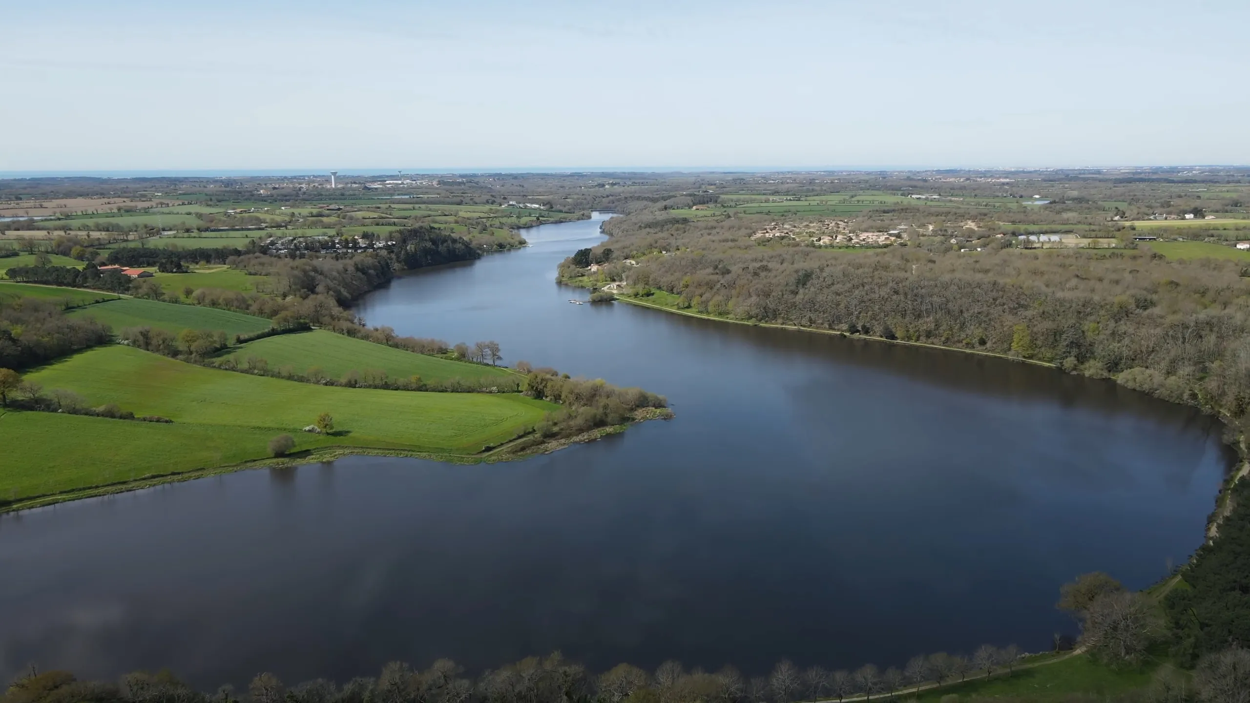 Paysage verdoyant du Lac du Jaunay en Vendée, montrant un lac de barrage sinueux entouré de collines et de sentiers de randonnée dans le bocage