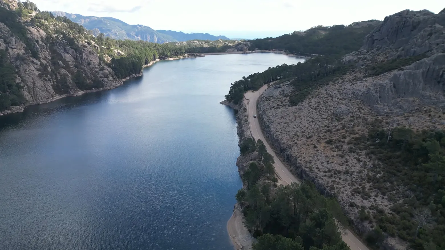 Le lac de barrage de l'Ospedale entouré de sa forêt de pins, rappelant les paysages canadiens