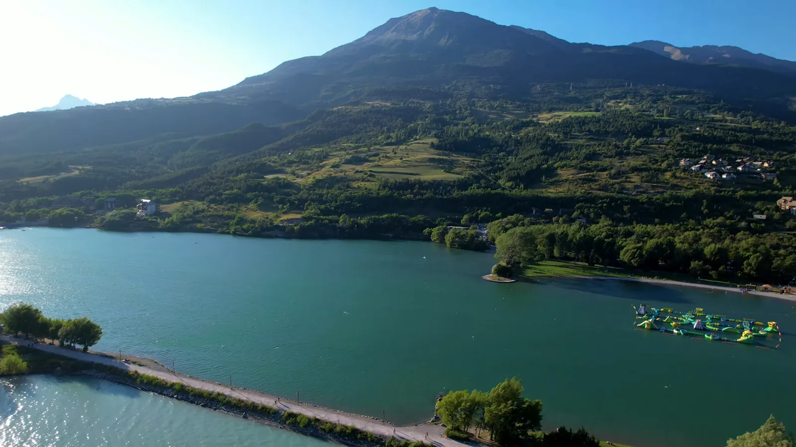 Plage et pelouses du Plan d'eau d'Embrun avec vue sur le Roc