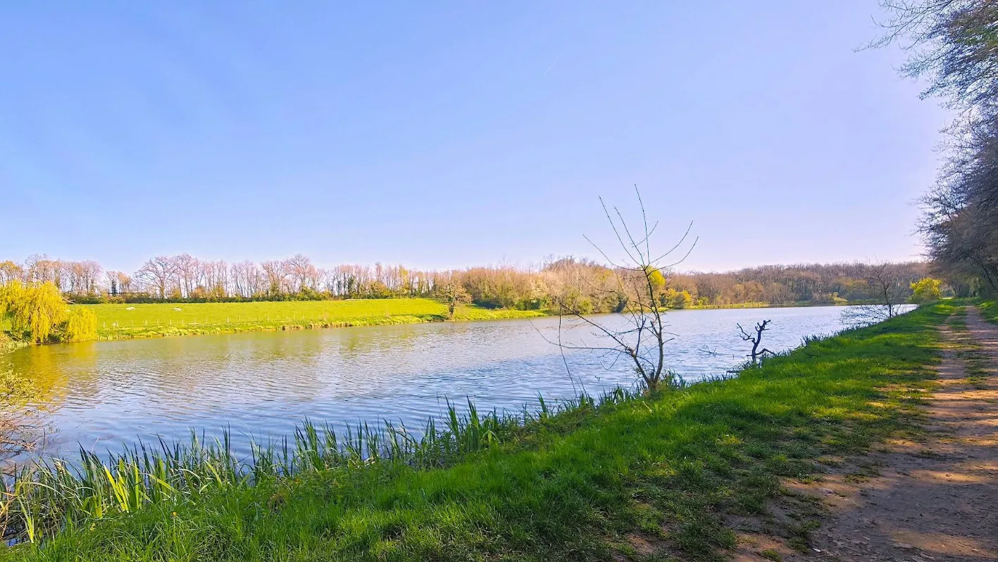 Le Château d'Ayron se reflétant dans le plan d'eau