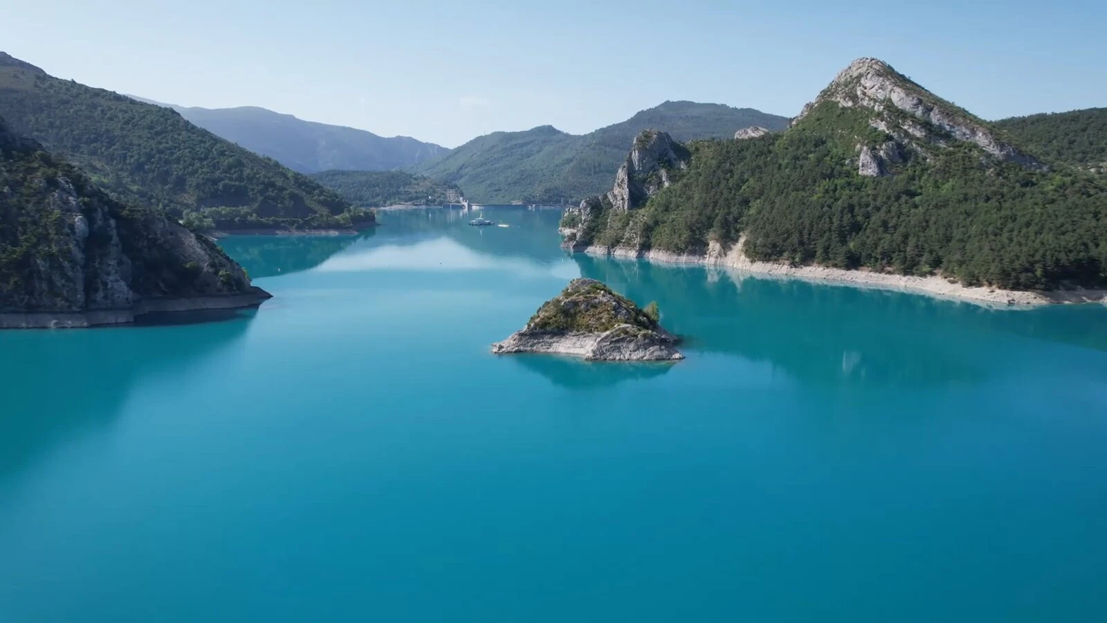 Les eaux turquoise du lac de Castillon et au loin son barrage construit à partir de 1929