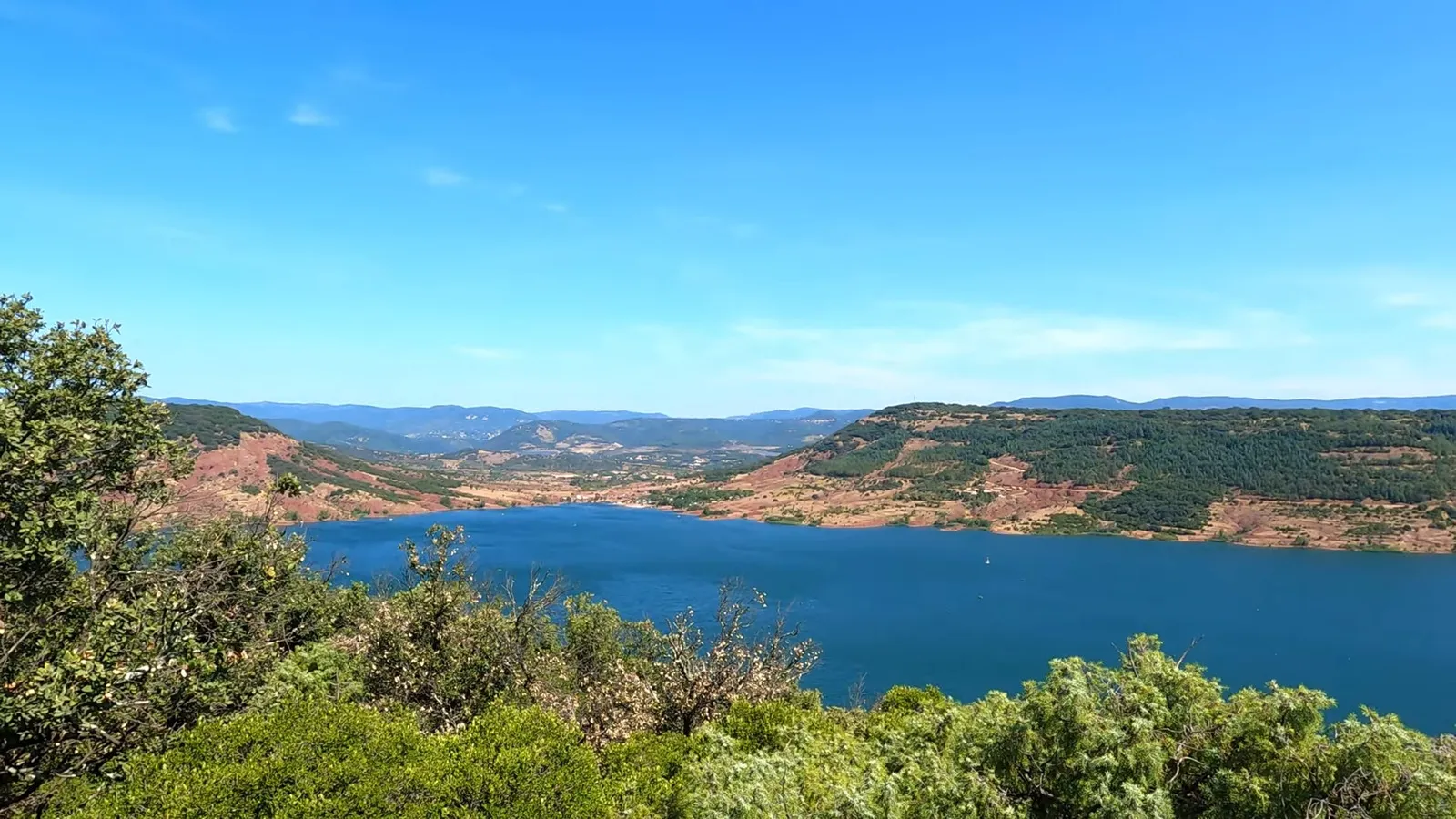 Randonnée autour du Lac du Salagou ruffe rouge, eau bleue, et vert de la végétation
